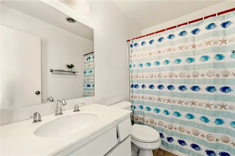 a bathroom with a sink a toilet and a shower curtain