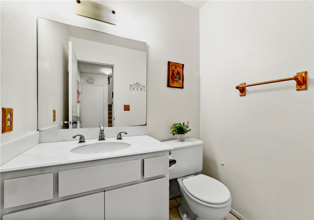 5132 West 1st Street, Unit B Santa Ana, CA 92703 - Photo 31 of 35 a bathroom with a toilet a sink and mirror