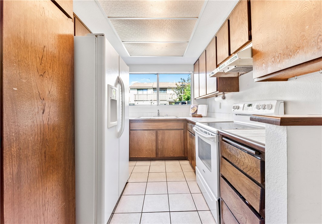 5132 West 1st Street, Unit B Santa Ana, CA 92703 - Photo 10 of 35 a kitchen with stainless steel appliances granite countertop a stove a sink and a refrigerator