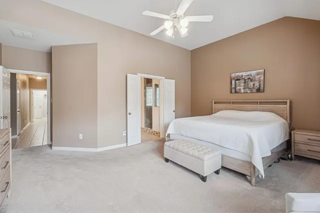a spacious bedroom with a bed and a chandelier