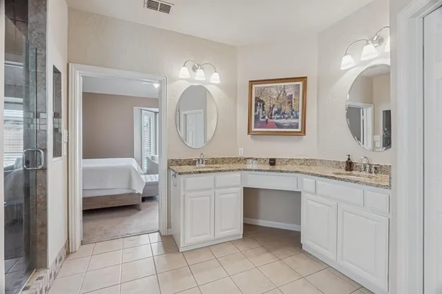 a en suite bathroom with a granite countertop sink mirror and vanity