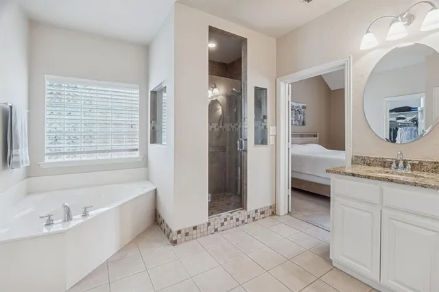 a spacious bathroom with a tub sink and mirror