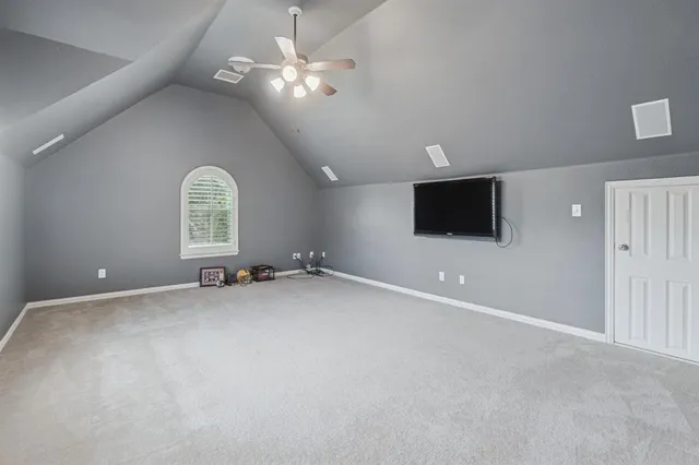 en empty room with windows and ceiling fan