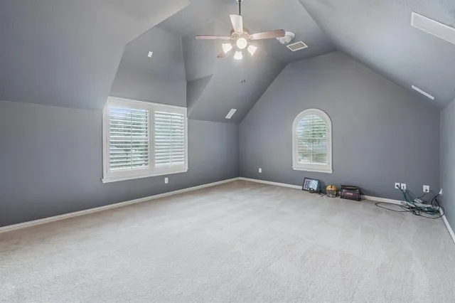 an empty room with a window and ceiling fan