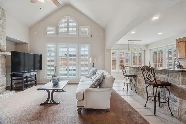 a living room with furniture a flat screen tv and a large window
