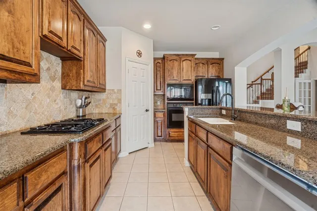a kitchen with stainless steel appliances granite countertop a stove and a sink