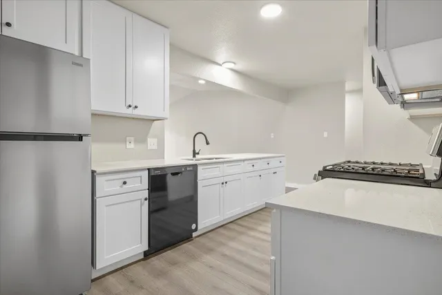 a kitchen with white cabinets and white appliances
