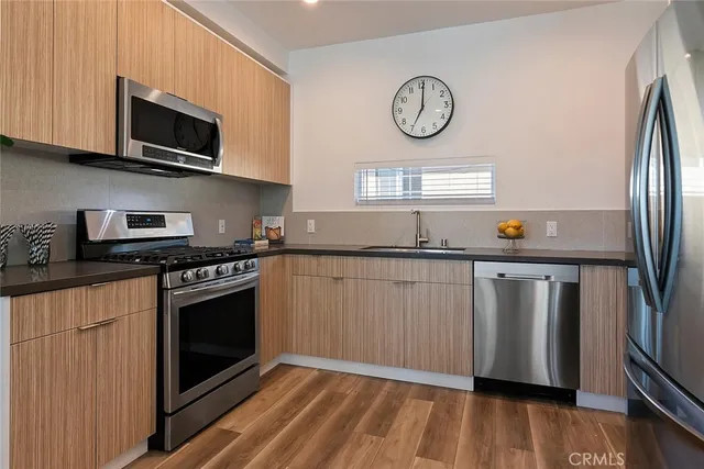 a kitchen with stainless steel appliances granite countertop a stove a microwave and a refrigerator