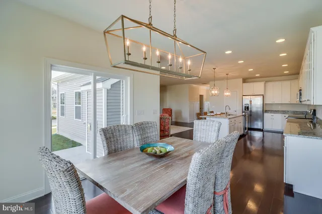 a view of a hallway with wooden floor and a living room