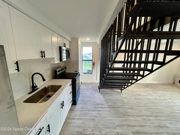 a view of hallway with a window and wooden floor