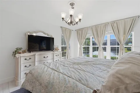 a spacious bedroom with a bed and a chandelier