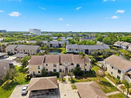 an aerial view of residential houses with outdoor space and trees
