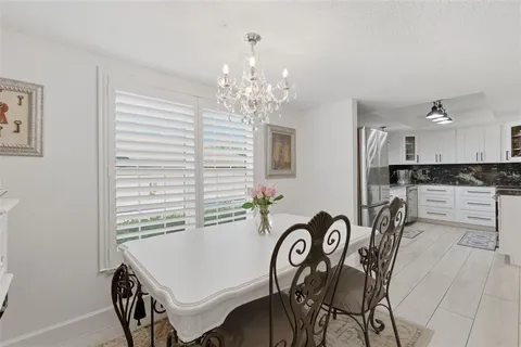 a view of a dining room with furniture and chandelier