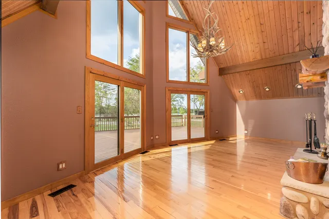 a view of a hall with wooden floor and a fireplace