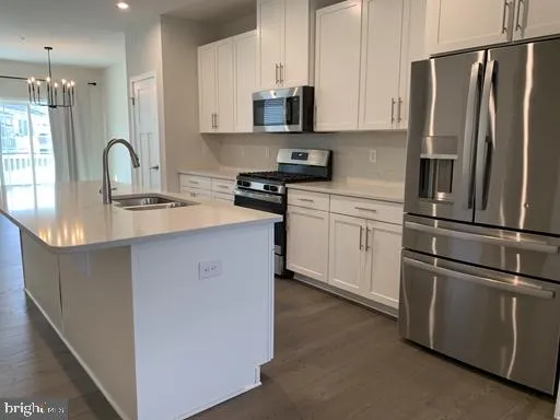 a kitchen with stainless steel appliances granite countertop a refrigerator sink and stove