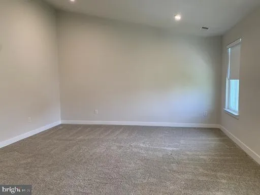 an empty room with windows and bathroom view