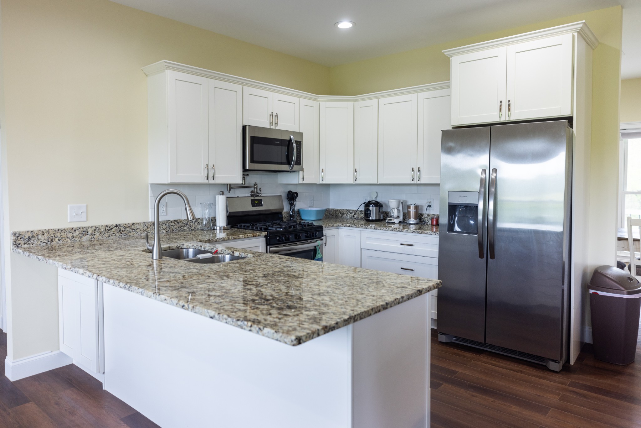 155 Colonial Road Hohenwald, TN 38462 - Photo 14 of 36 a kitchen with stainless steel appliances granite countertop a sink a microwave a refrigerator and white cabinets