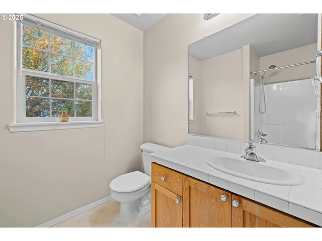 a bathroom with a sink a toilet and a window