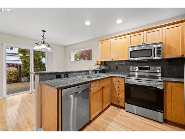 a kitchen with stainless steel appliances granite countertop a stove microwave and sink