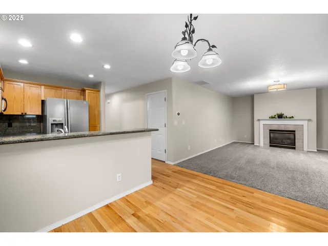 a view of an empty room with a fireplace and a window