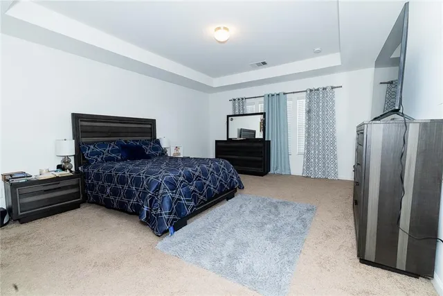 a bedroom with a bed dresser and a large mirror