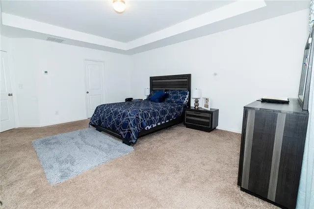 a bedroom with a bed and a refrigerator