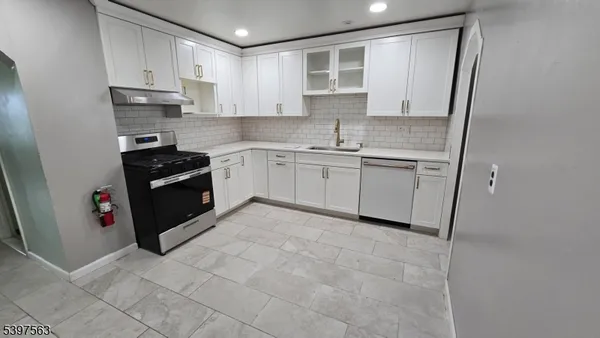a kitchen with stainless steel appliances granite countertop a stove top oven a sink and a granite counter tops