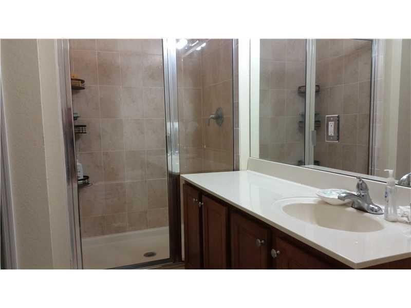 20767 Northeast 10th Path, Unit 20767 Miami, FL 33179 - Photo 15 of 26 a bathroom with a sink a shower a mirror and a bathtub