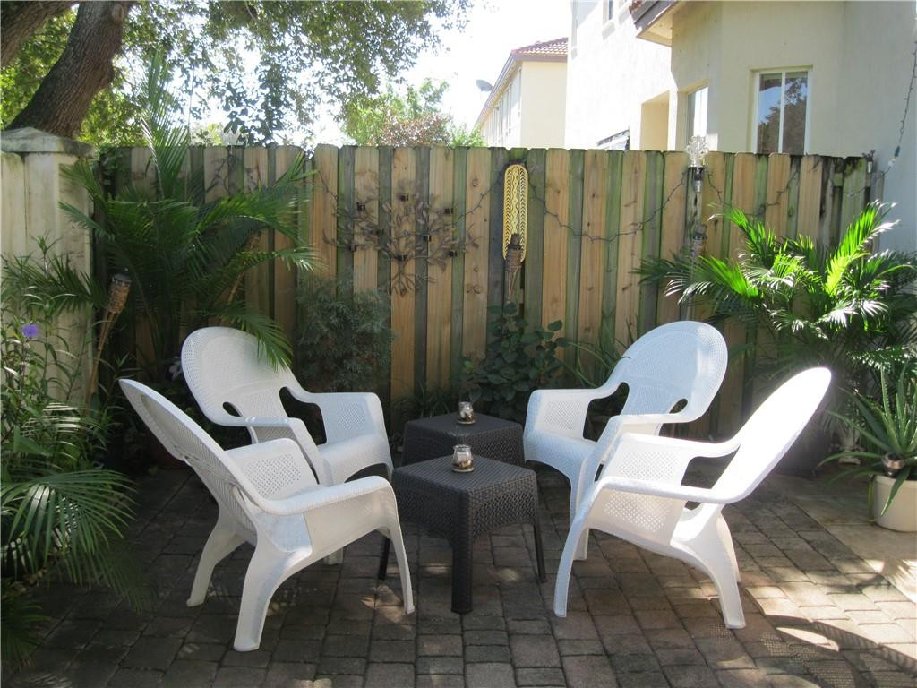 20767 Northeast 10th Path, Unit 20767 Miami, FL 33179 - Photo 20 of 26 a view of a chairs and table in backyard of the house