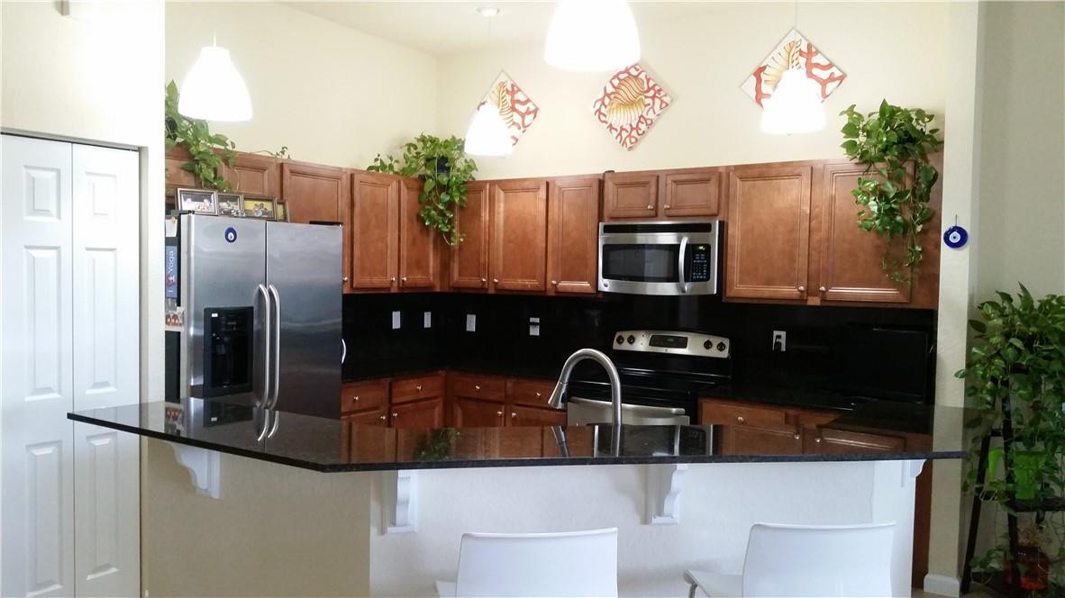 20767 Northeast 10th Path, Unit 20767 Miami, FL 33179 - Photo 2 of 26 a kitchen with stainless steel appliances granite countertop a sink and a refrigerator