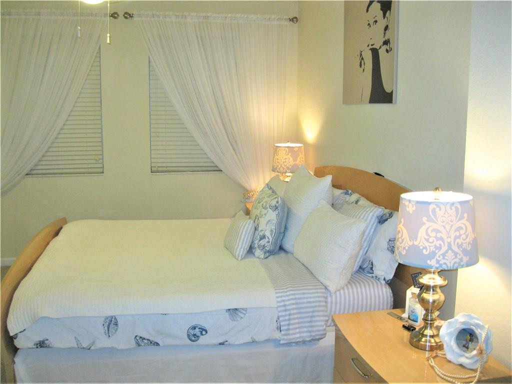 20767 Northeast 10th Path, Unit 20767 Miami, FL 33179 - Photo 10 of 26 a bed sitting in a bedroom next to a window