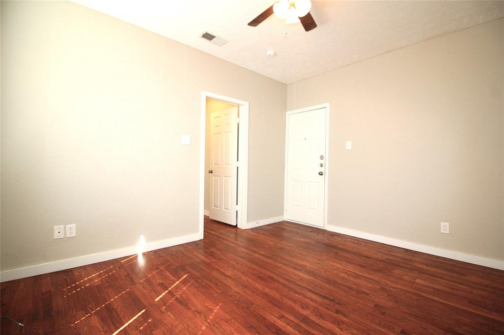 2309 Wesley Street, Unit D Greenville, TX 75401 - Photo 12 of 16 an empty room with wooden floor and fan