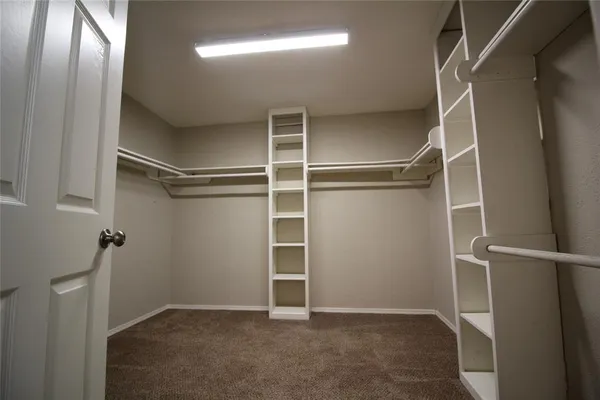 an empty room with wooden floor cabinet and windows