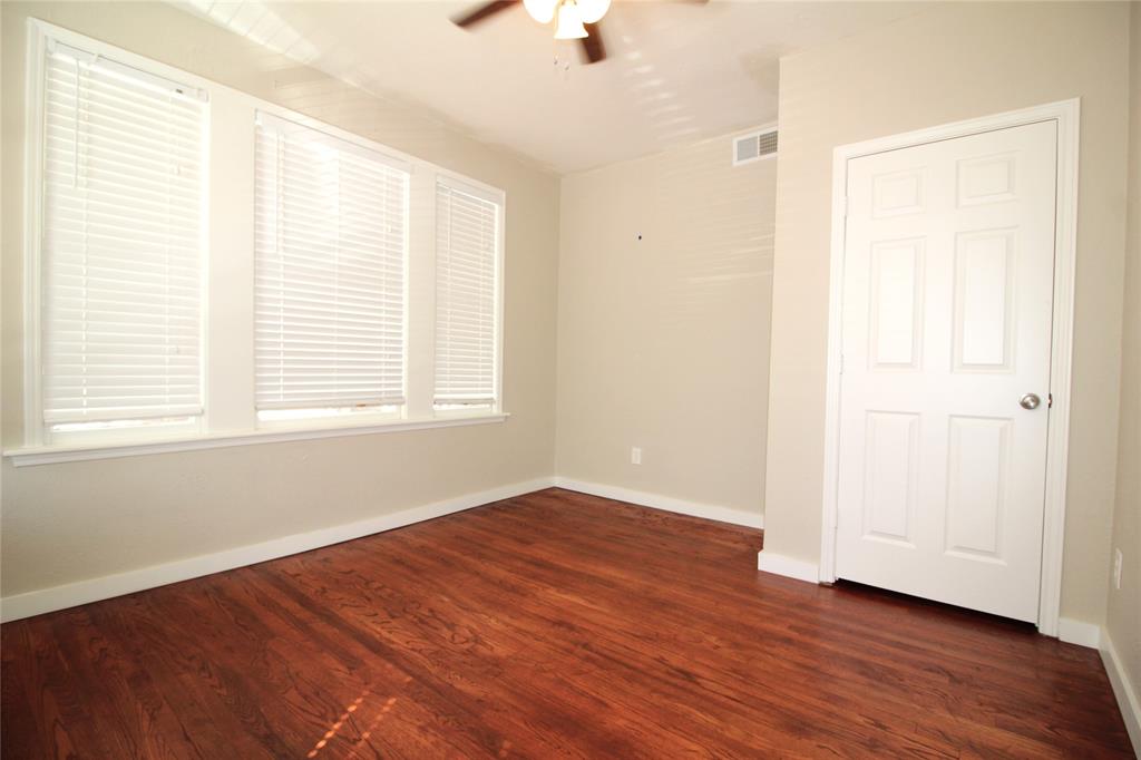 2309 Wesley Street, Unit D Greenville, TX 75401 - Photo 14 of 16 an empty room with wooden floor cabinet and windows