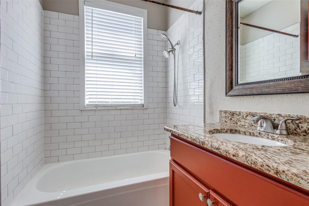 2309 Wesley Street, Unit D Greenville, TX 75401 - Photo 7 of 16 a bathroom with a granite countertop sink and a bathtub