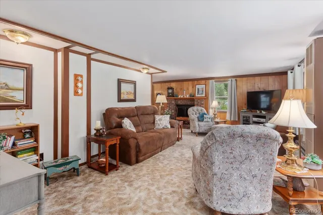 a living room with furniture fireplace and a large window