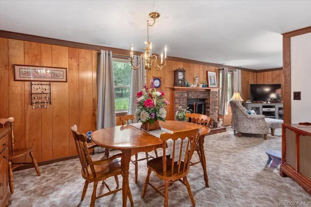 a view of a dining room with furniture a chandelier and window