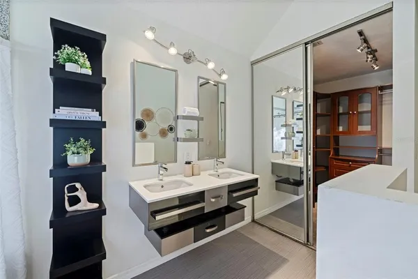 a en suite bathroom with a double vanity sink and a mirror