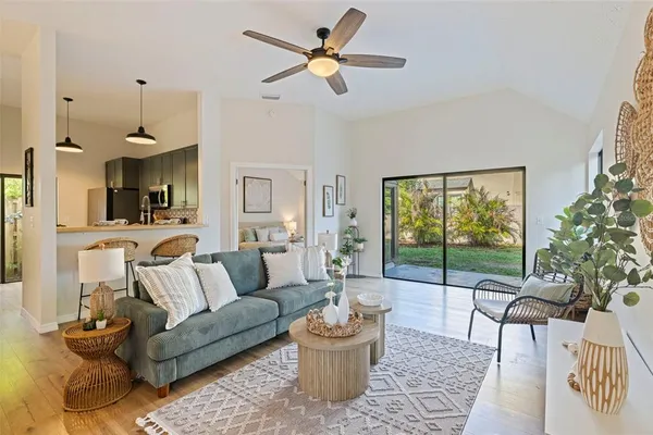 a living room with furniture and a large window with wooden floor
