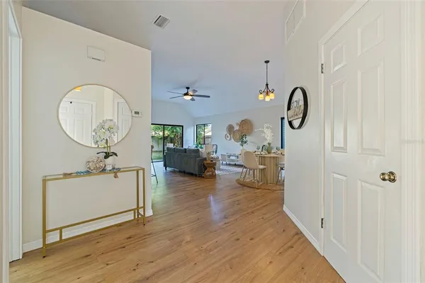 a living room with couches a dining table with wooden floor