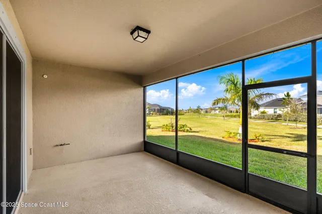 a view of an empty room with large windows