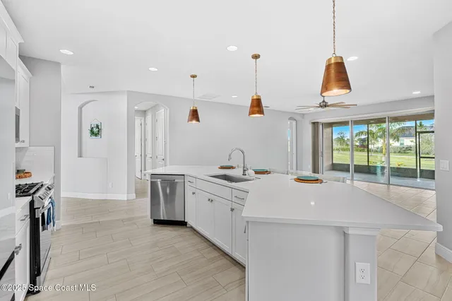 a kitchen with a stove a sink a wooden floor and a window