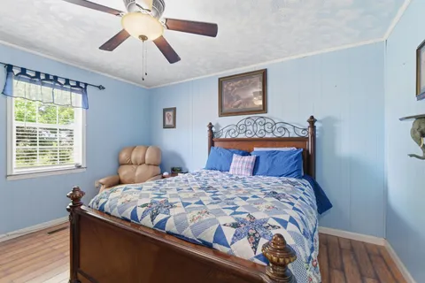 a bedroom with a bed and a lamp on dresser