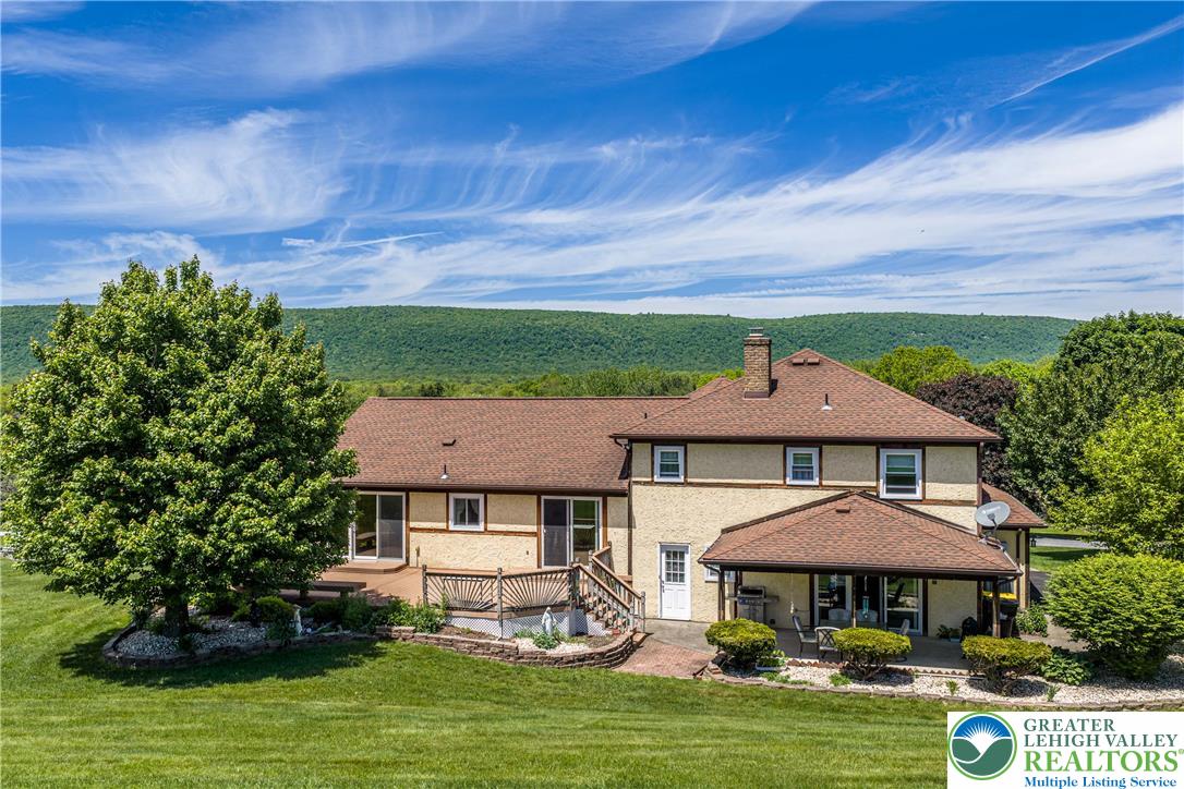 947 Tamenend Road Bath, PA 18014 - Photo 50 of 61 An inviting exterior with a covered patio and a spacious deck overlooks rolling hills and verdant trees.