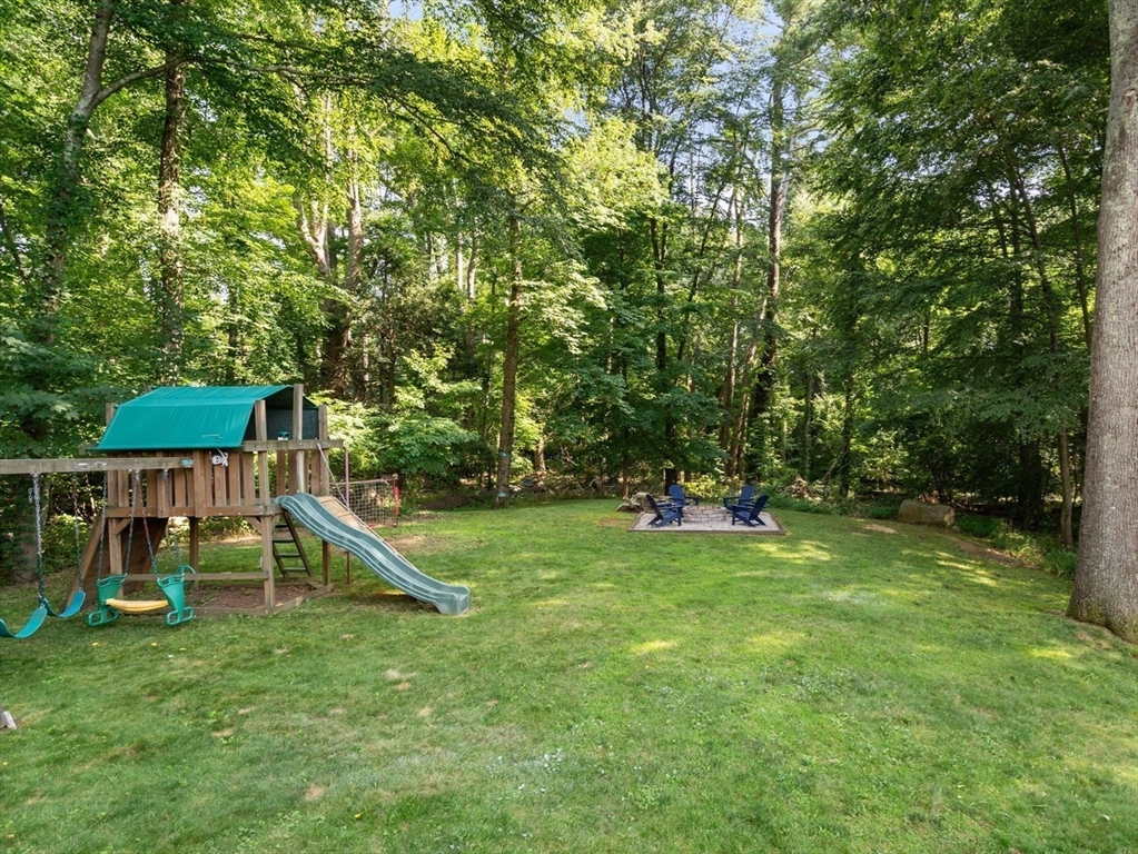 330 Gorwin Drive Holliston, MA 01746 - Photo 22 of 27 a view of a backyard with a slide trees and wooden fence