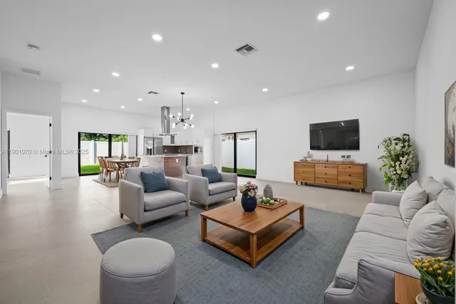 a living room with furniture flat screen tv and couches