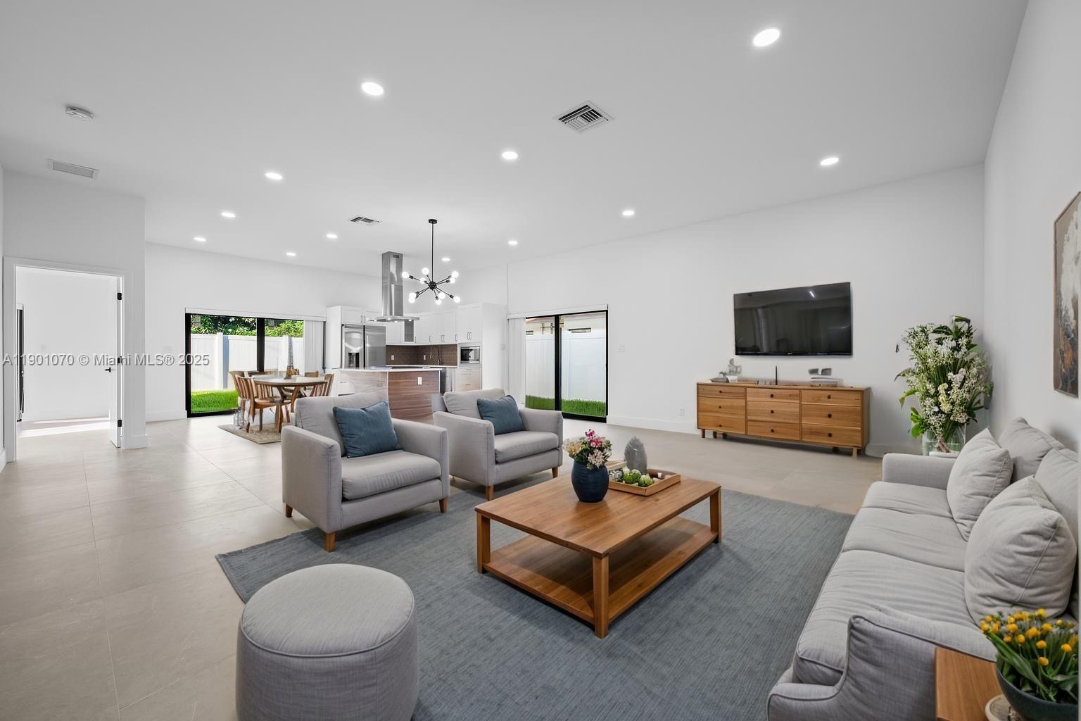 a living room with furniture flat screen tv and couches