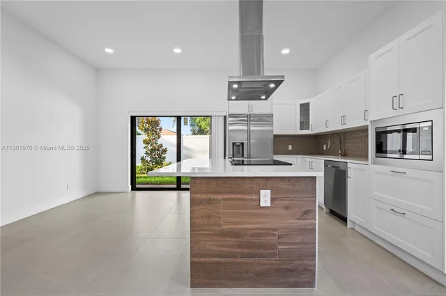 a kitchen with stainless steel appliances granite countertop a stove a sink and a refrigerator