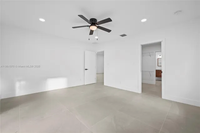a view of an empty room with a ceiling fan