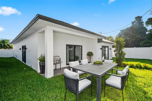 a view of an house with backyard and furniture